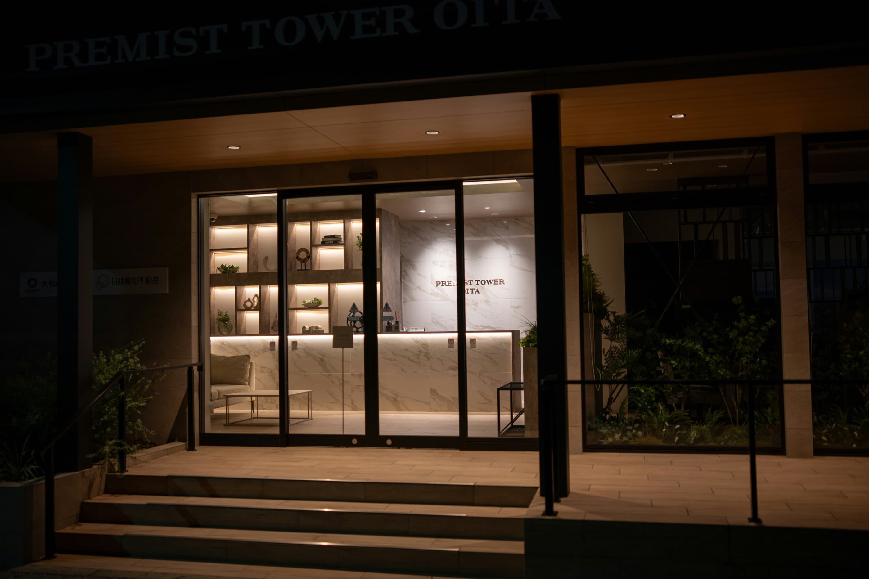 A lit hotel lobby at night with nobody at the desk